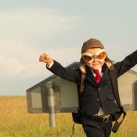 boy in an airoplane costume running in a field